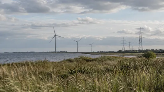 Illustrationsbild av dansk energiinfrastruktur med vindkraft och kraftledningar
