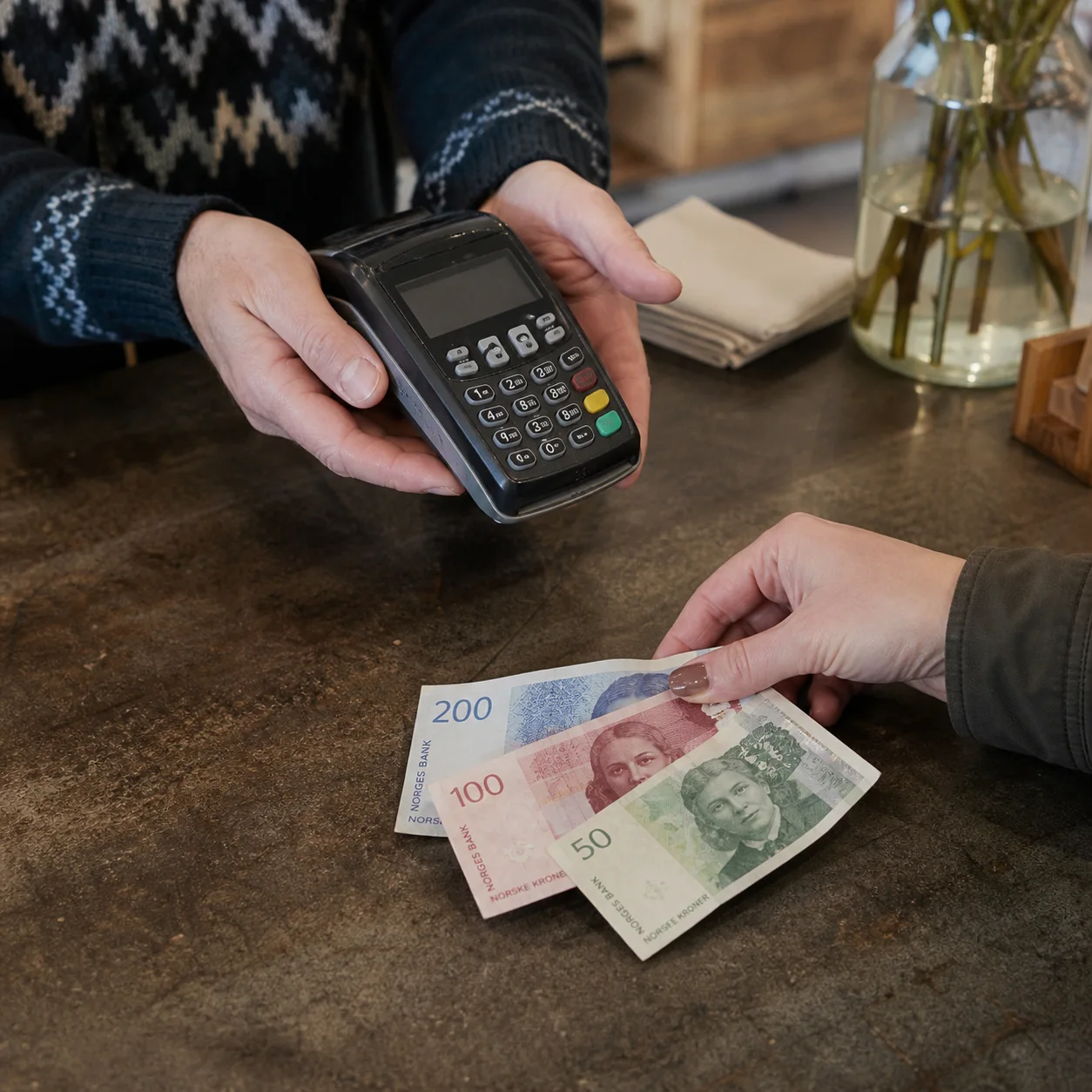 Norska kronor och en kortterminal i en butik.